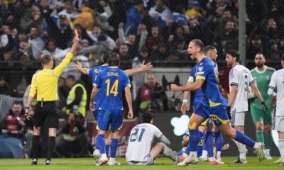 Referee Clement Turpin shows a red card to Italy's Alessandro Bastoni (21) during the World Cup qualifying playoff final soccer match between Bosnia and Italy in Zenica, Bosnia, Tuesday, March 31, 2026. . (Fabio Ferrari/LaPresse via AP)