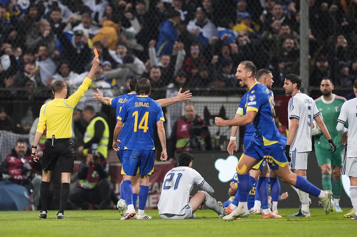 Referee Clement Turpin shows a red card to Italy's Alessandro Bastoni (21) during the World Cup qualifying playoff final soccer match between Bosnia and Italy in Zenica, Bosnia, Tuesday, March 31, 2026. . (Fabio Ferrari/LaPresse via AP)