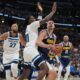 Denver Nuggets center Nikola Jokic, front right, drives the lane as Minnesota Timberwolves centers Naz Reid, center left, and Rudy Gobert, left, defend in the first half in Game 5 of a first-round NBA playoffs basketball series Monday, April 27, 2026, in Denver. (AP Photo/David Zalubowski)