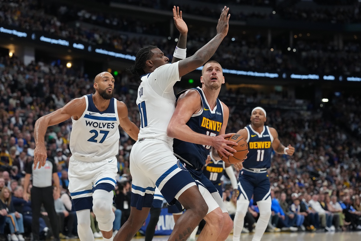 Denver Nuggets center Nikola Jokic, front right, drives the lane as Minnesota Timberwolves centers Naz Reid, center left, and Rudy Gobert, left, defend in the first half in Game 5 of a first-round NBA playoffs basketball series Monday, April 27, 2026, in Denver. (AP Photo/David Zalubowski)