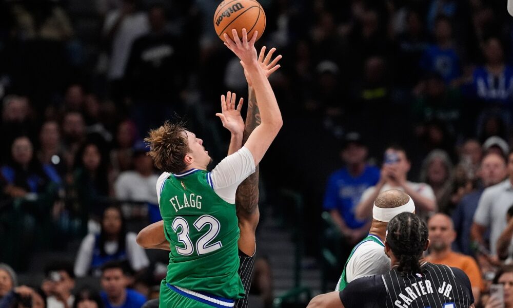 Dallas Mavericks forward Cooper Flagg (32) is fouled by Orlando Magic's Jamal Cain, rear, as Flagg sinks a basket for his 50th point of the game late in the second half of an NBA basketball game Friday, April 3, 2026, in Dallas. (AP Photo/Tony Gutierrez)