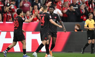 Leverkusen's Patrik Schick, centre, celebrates with Edmond Tapsoba, right, and Ibrahim Maza after scoring the opening goal during the German Bundesliga soccer match between Bayer Leverkusen and RB Leipzig in Leverkusen, Germany, Saturday, May 2, 2026. (Fabian Strauch/dpa via AP)
