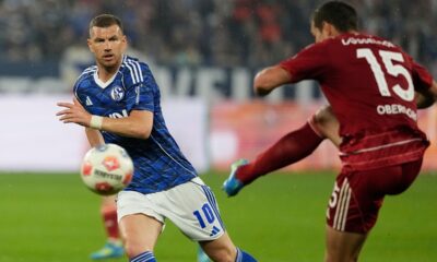 Schalke's Edin Dzeko, left, tries to block a shot from Duesseldorf's Tim Oberdorf during the German Bundesliga 2 soccer match between FC Schalke 04 and Fortuna Duesseldorf in Gelsenkirchen, Germany, Saturday, May 2, 2026. (AP Photo/Martin Meissner)