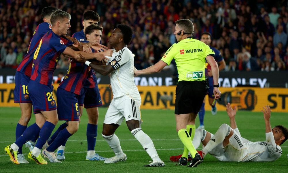 Real Madrid's Vinicius Junior argues with Barcelona players during the Spanish La Liga soccer match between FC Barcelona and Real Madrid in Barcelona, Spain, Sunday, May 10, 2026. (AP Photo/Joan Monfort)