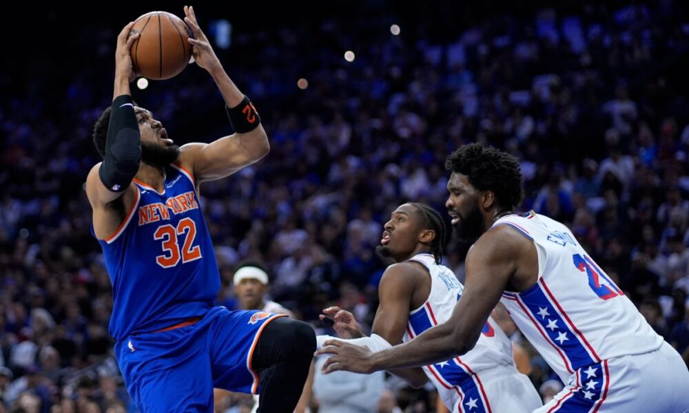 New York Knicks' Karl-Anthony Towns, from left, goes up for a shot against Philadelphia 76ers' Tyrese Maxey, and Joel Embiid during the first half of Game 4 in a second-round NBA basketball playoffs series Sunday, May 10, 2026, in Philadelphia. (AP Photo/Matt Slocum)