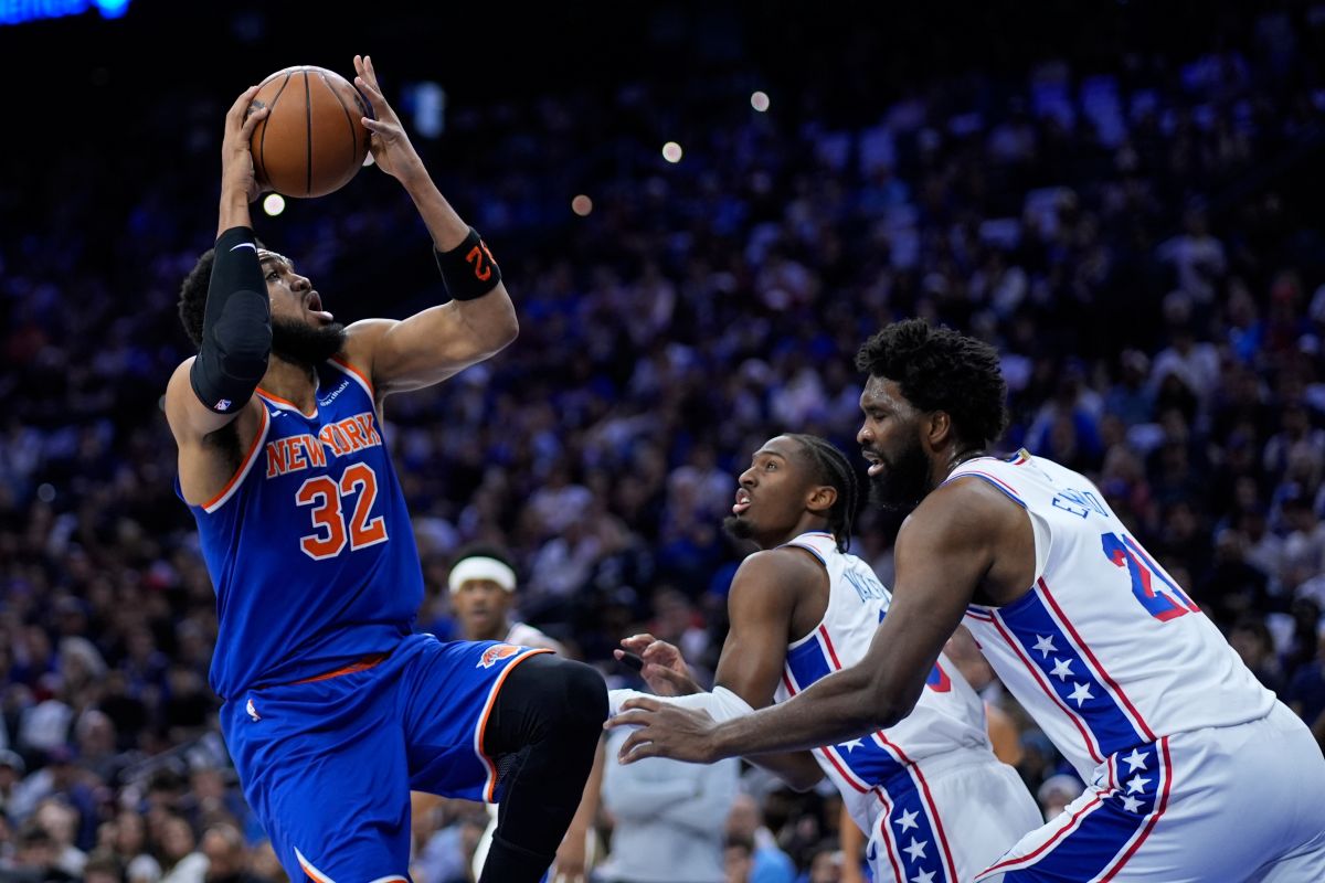 New York Knicks' Karl-Anthony Towns, from left, goes up for a shot against Philadelphia 76ers' Tyrese Maxey, and Joel Embiid during the first half of Game 4 in a second-round NBA basketball playoffs series Sunday, May 10, 2026, in Philadelphia. (AP Photo/Matt Slocum)