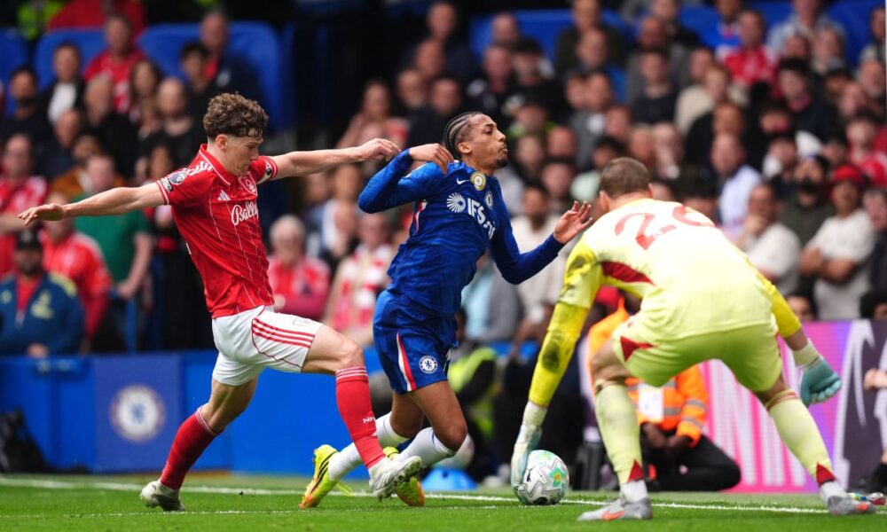 Chelsea's Joao Pedro, center, falls to the ground after pressure from Nottingham Forest's Ryan Yates during the English Premier League soccer match between Chelsea and Nottingham Forest in London, Monday, May 4, 2026. (John Walton/PA via AP)