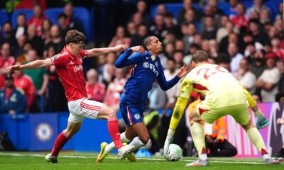 Chelsea's Joao Pedro, center, falls to the ground after pressure from Nottingham Forest's Ryan Yates during the English Premier League soccer match between Chelsea and Nottingham Forest in London, Monday, May 4, 2026. (John Walton/PA via AP)