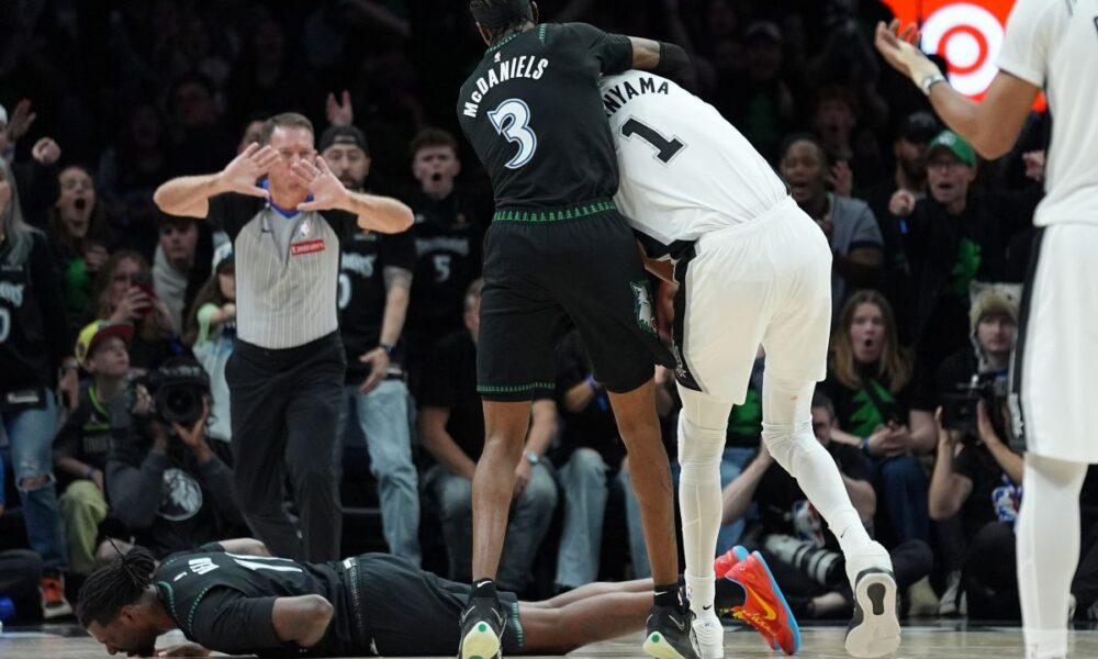 Minnesota Timberwolves center Naz Reid (11) falls to the court after he was fouled by San Antonio Spurs forward Victor Wembanyama (1) as he and forward Jaden McDaniels (3) battled for a rebound during the first half of Game 4 of an NBA basketball second-round playoffs series in Minneapolis, Sunday, May 10, 2026. (AP Photo/Abbie Parr)