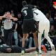 Minnesota Timberwolves center Naz Reid (11) falls to the court after he was fouled by San Antonio Spurs forward Victor Wembanyama (1) as he and forward Jaden McDaniels (3) battled for a rebound during the first half of Game 4 of an NBA basketball second-round playoffs series in Minneapolis, Sunday, May 10, 2026. (AP Photo/Abbie Parr)