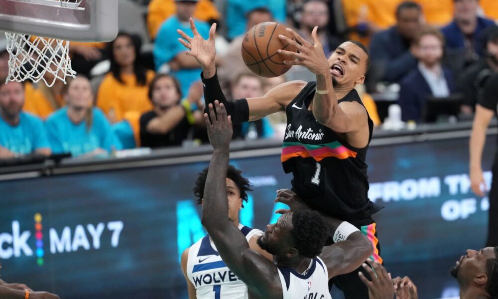 San Antonio Spurs forward Victor Wembanyama (1) reaches for the ball as Minnesota Timberwolves forward Julius Randle (30) defends during the second half in Game 1 of a second-round NBA playoffs basketball series in San Antonio, Monday, May 4, 2026. (AP Photo/Eric Gay)