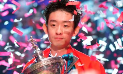 China's poses for the media with the trophy and wearing the Chinese national flag, after winning the World Snooker Championship defeating England's Shaun Murphy in Sheffield, England, Monday, May 4, 2026.(AP Photo/Ian Hodgson)