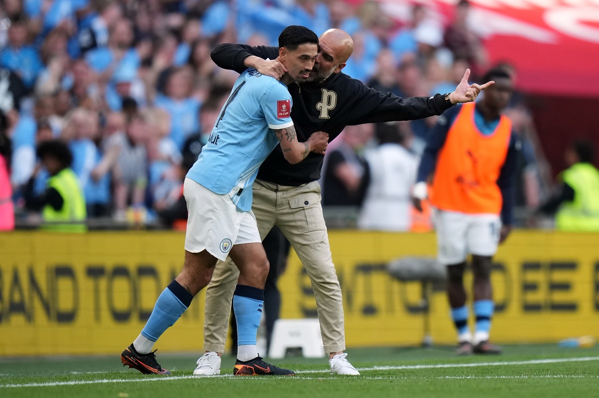 Manchester City's head coach Pep Guardiola talks to Tijjani Reijnders during the FA Cup semifinal soccer match between Manchester City and Southampton in Manchester, England, Saturday, April 25, 2026. (AP Photo/Alastair Grant)
